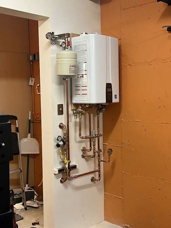 Plumbing technician inspecting water heater connections in Idabel